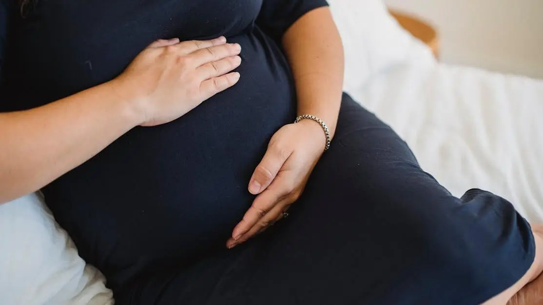 Expectant woman stroking tummy while resting, highlighting Pregnancy and Yeast Infections.