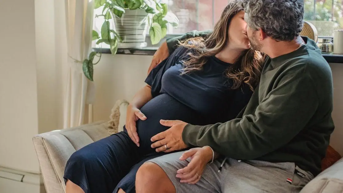 Expecting couple kissing on daybed to prevent BV during pregnancy