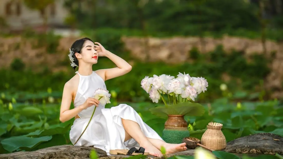 Woman meditating on a lotus pond, symbolizing Progesterone Therapy for Hot Flashes.