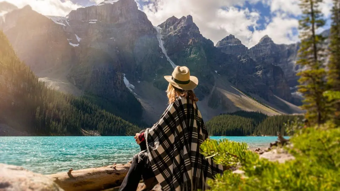 Woman relaxing by a lake, embodying serenity and reducing stress to prevent bacterial vaginosis.