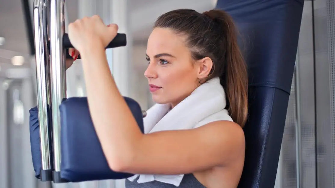 Woman performing strength training at gym during menopause.