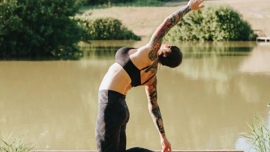 Flexible woman practicing stress management exercise on dock for recurring BV prevention