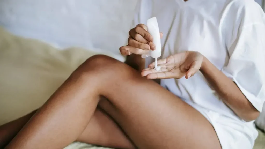 Woman applying cream to sweat rash in cleavage