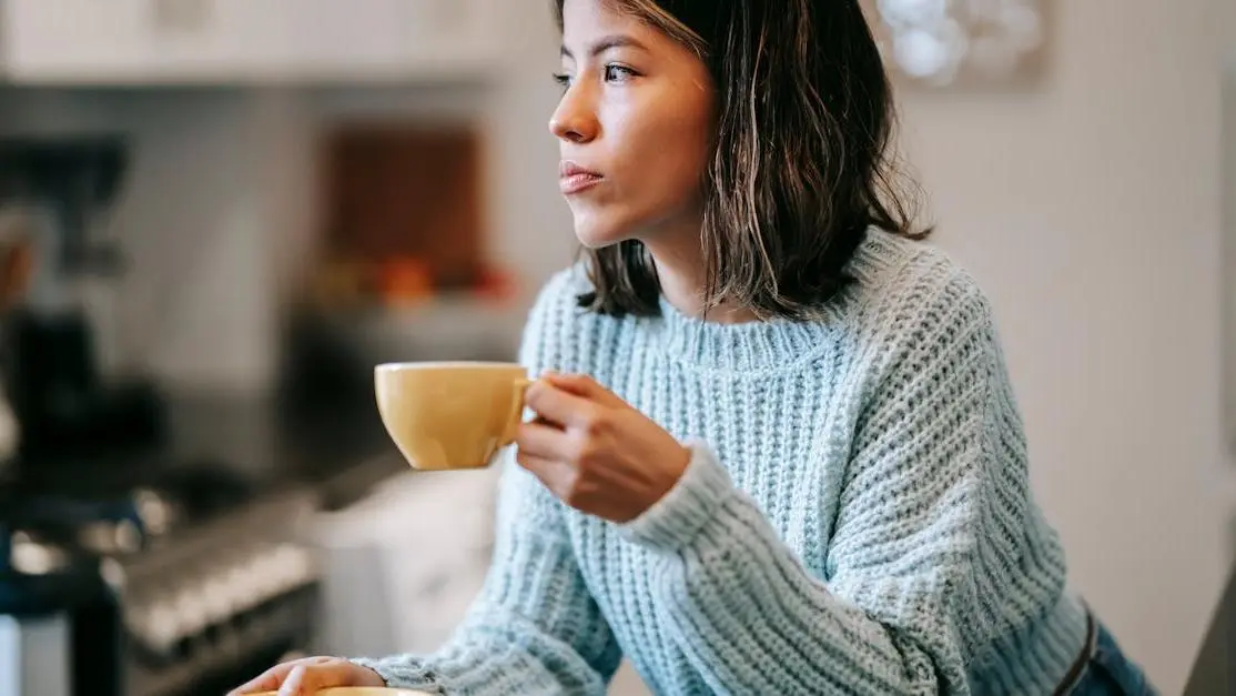 Woman in kitchen experiencing hot flashes while considering testosterone therapy