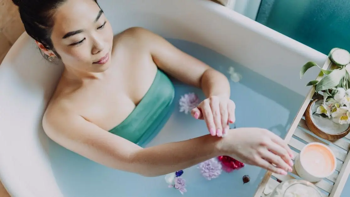 Woman relaxing in bathtub applying treatment for sweat rash