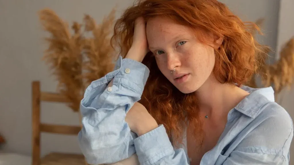 Young woman showing underboob heat rash.