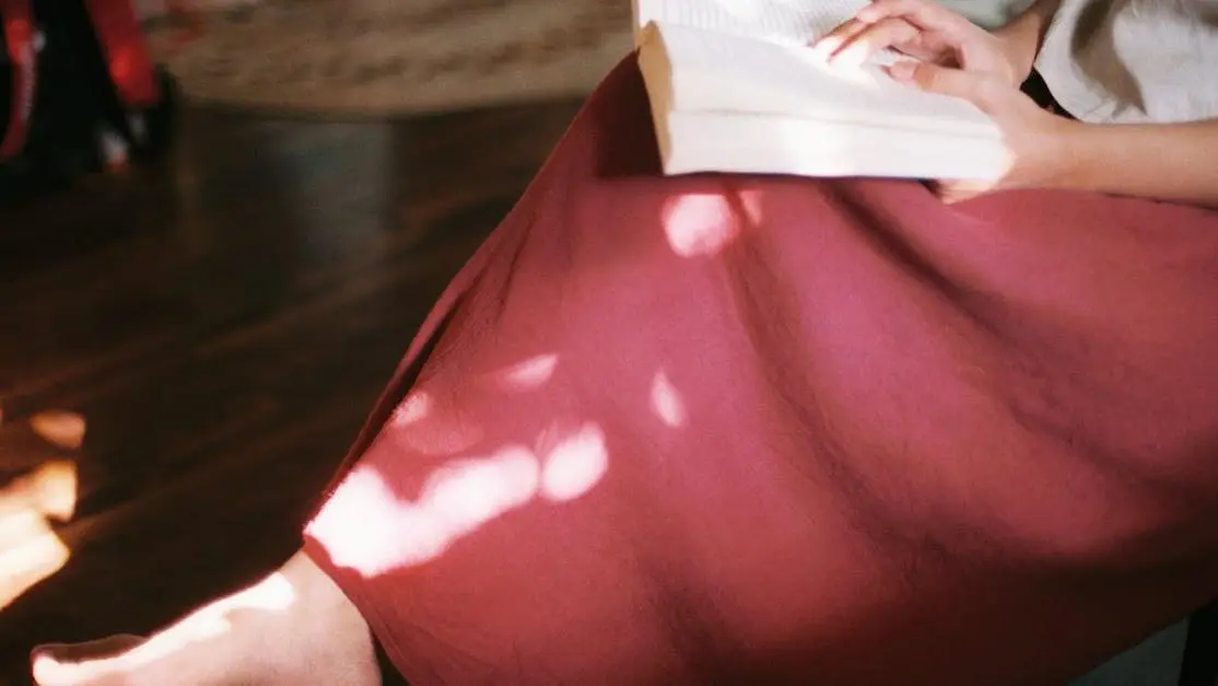 Woman in 30s reading a book at home, dealing with vaginal dryness solutions