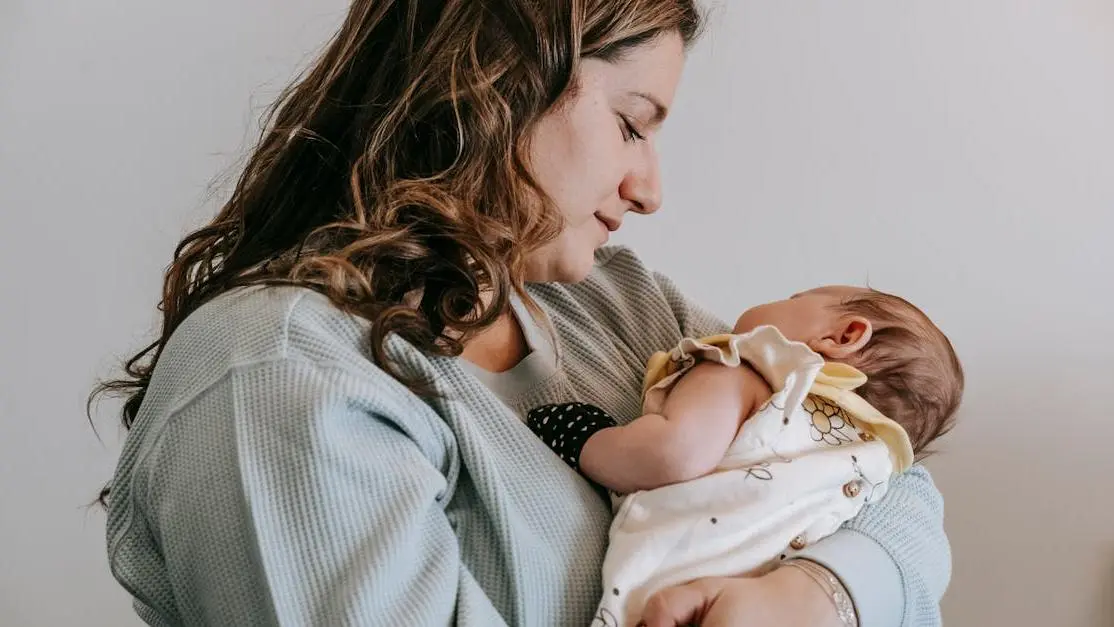 Mother holding baby, addressing vaginal odor postpartum