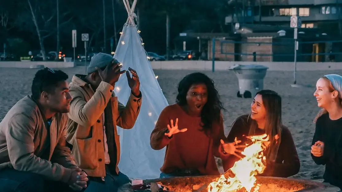 Friends experiencing menopause hot flashes sitting around a fire pit.