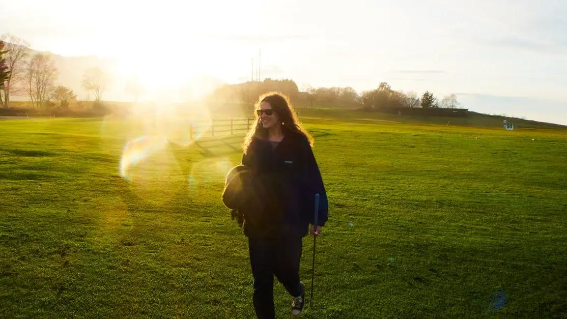 Woman walking in sunny green field, illustrating "Berberine May Help With Weight Loss" concept.