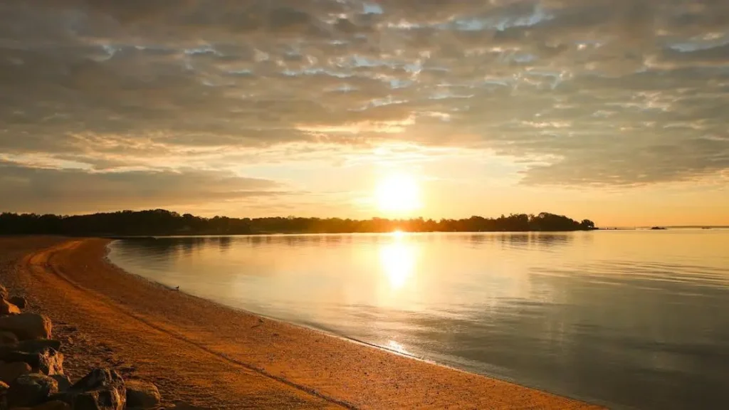 Sunrise over water with sandy beach, highlighting article on GLP-1 Medications and Menopause.