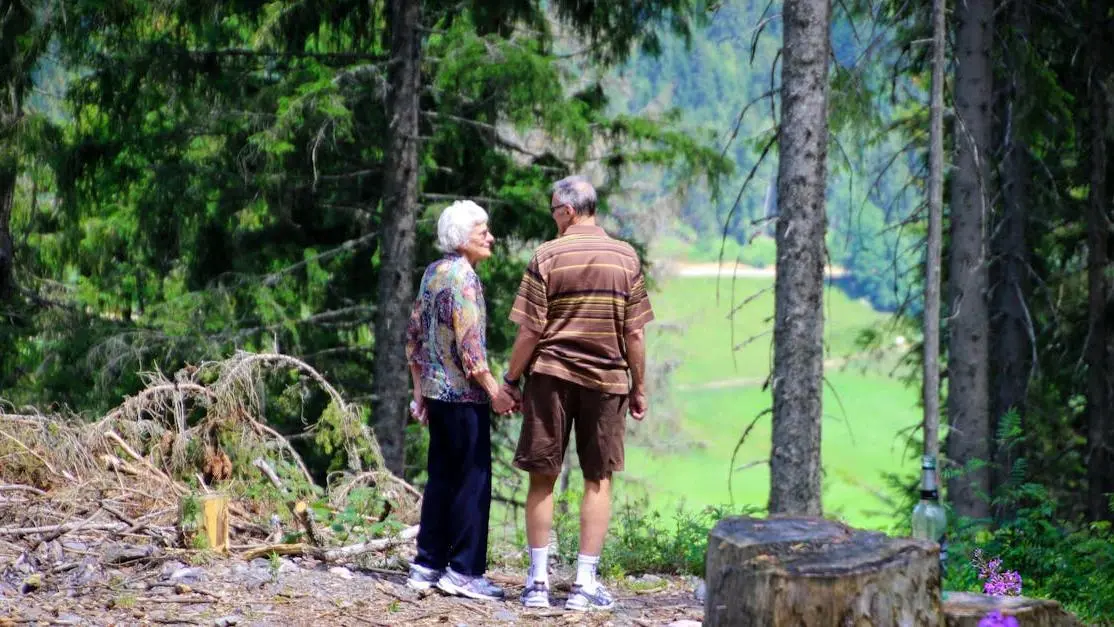 Elderly couple holding hands on a forest trail, illustrating the journey of starting a Semaglutide program.