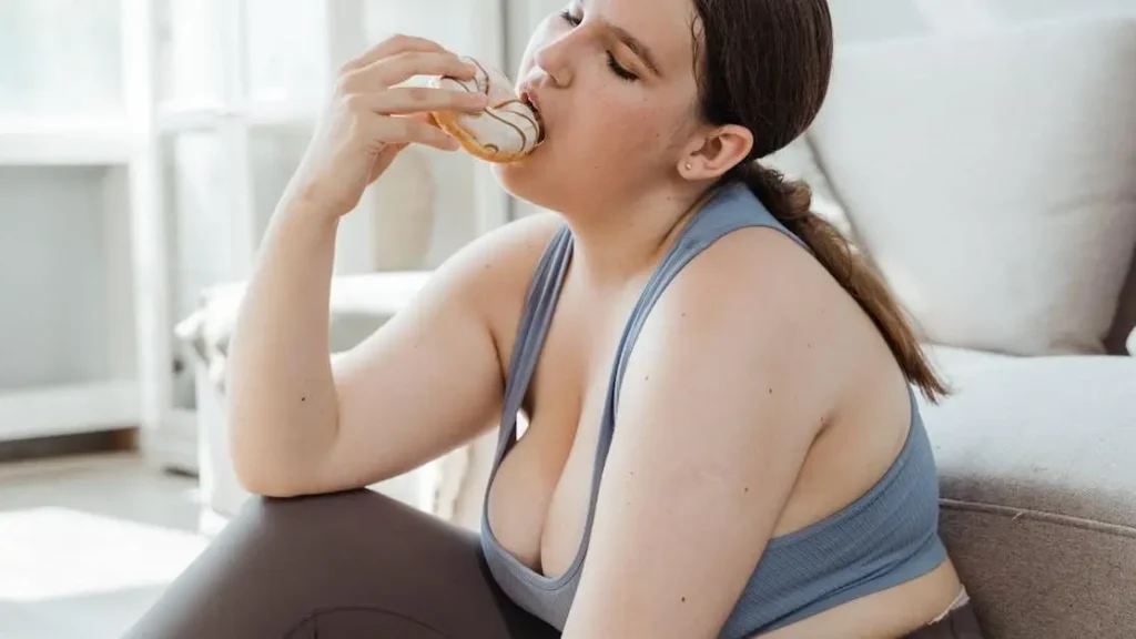 Woman in activewear enjoying a donut, illustrating GLP-1 help with appetite control.